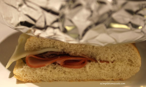 Cuban sandwich being pressed by foil covered weight