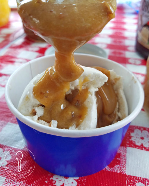 peacan praline sauce being poured over ice cream