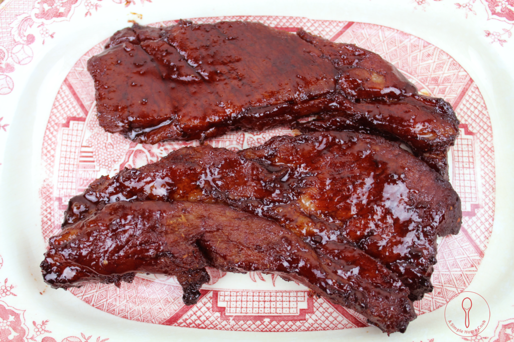 Two slabs of red-hued Char Siu pork roast on a platter