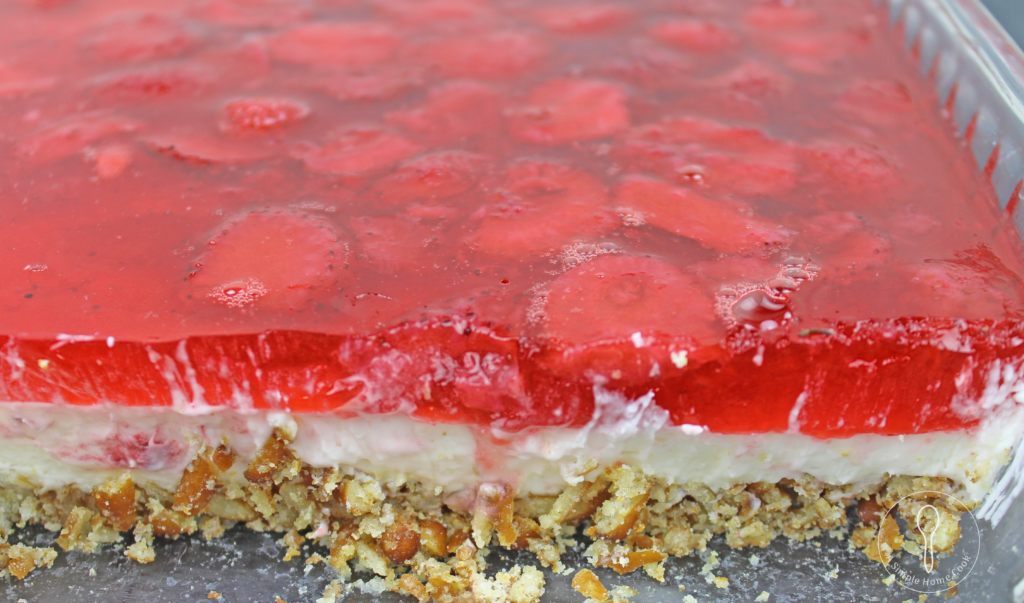 side view of cut dessert with pretzel crust, white cream, and gelatin layers